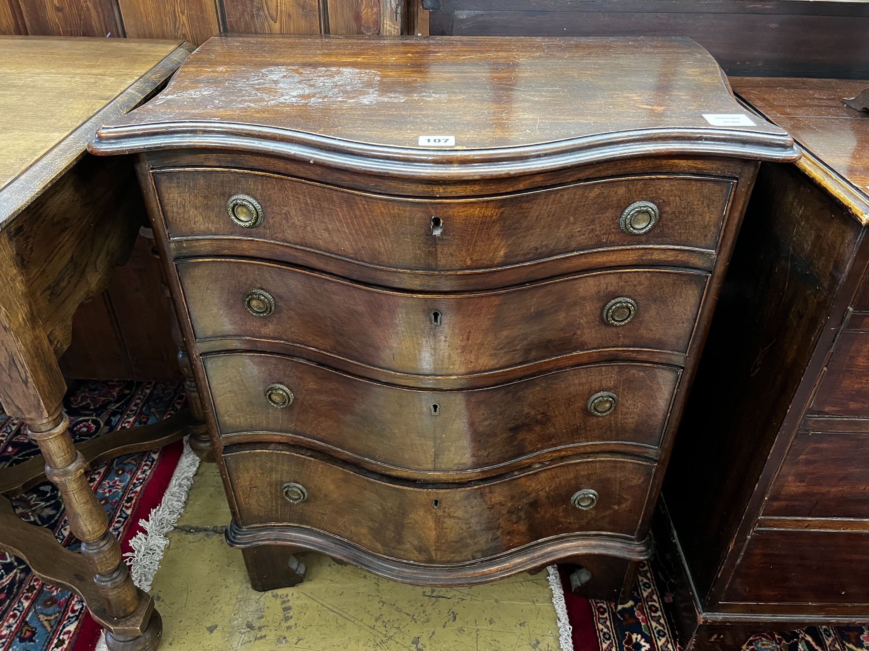 A small George III style mahogany serpentine chest of four drawers, width 65cm, depth 43cm, height 77cm